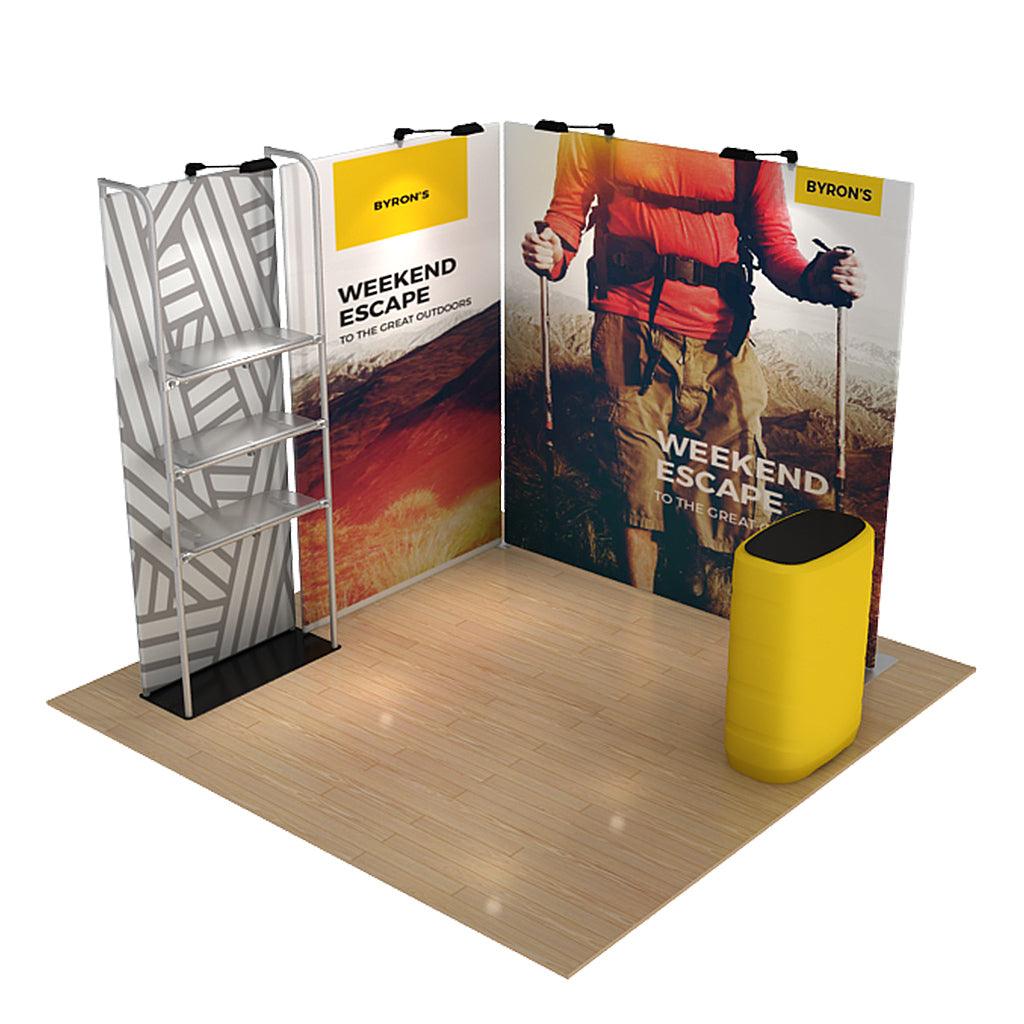 Trade show display with graphic panels featuring outdoor adventure theme and shelving unit for product showcasing