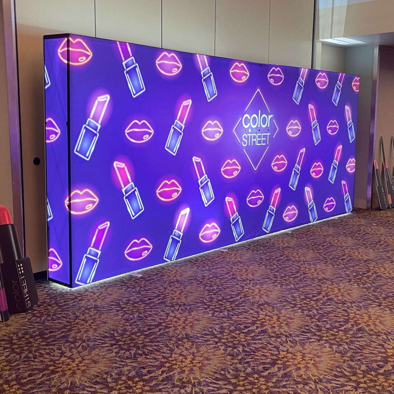 Large illuminated trade show backdrop featuring lipstick and lips graphics with Color Street branding