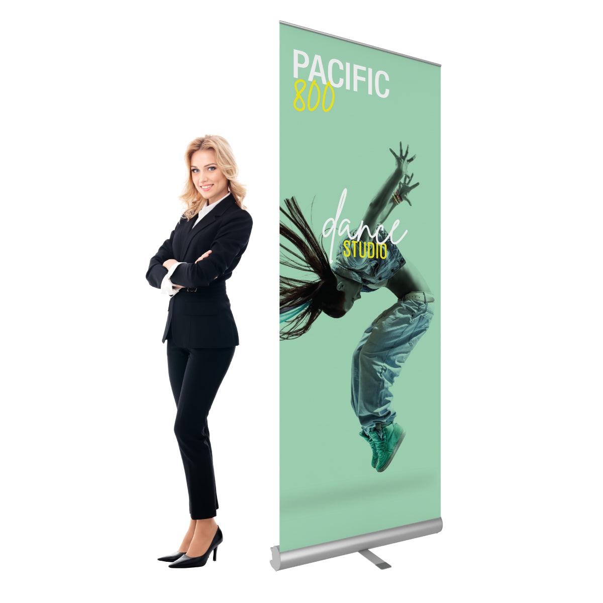 Retractable banner stand with dance studio promotion next to businesswoman, ideal for trade shows and events