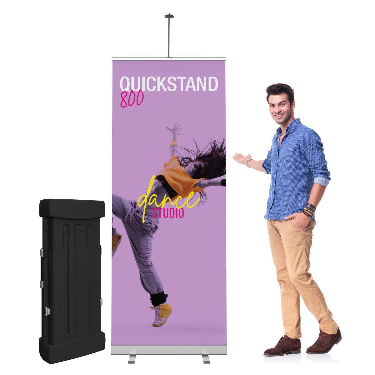Man presenting portable Quickstand 800 banner stand for trade shows and exhibitions with dance studio graphic