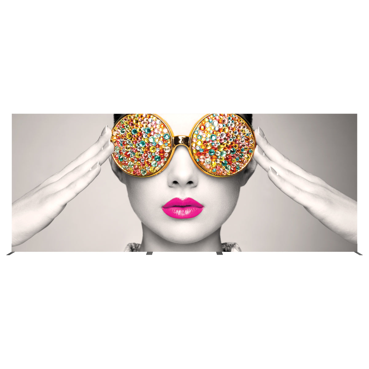 Large trade show display featuring artistic close-up of woman wearing bejeweled sunglasses and bold lipstick