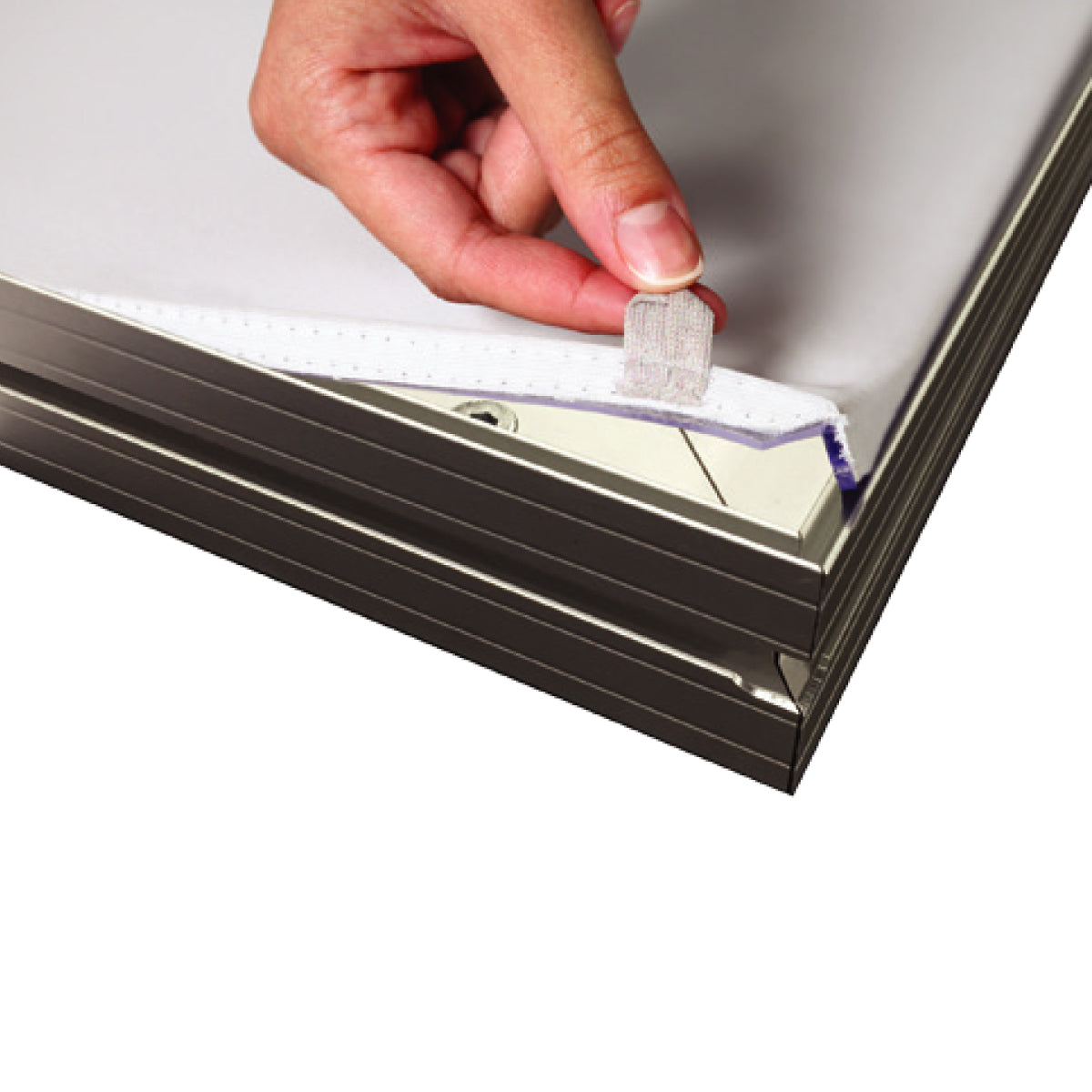 Hand attaching silicone edge graphic to aluminum frame for trade show display setup