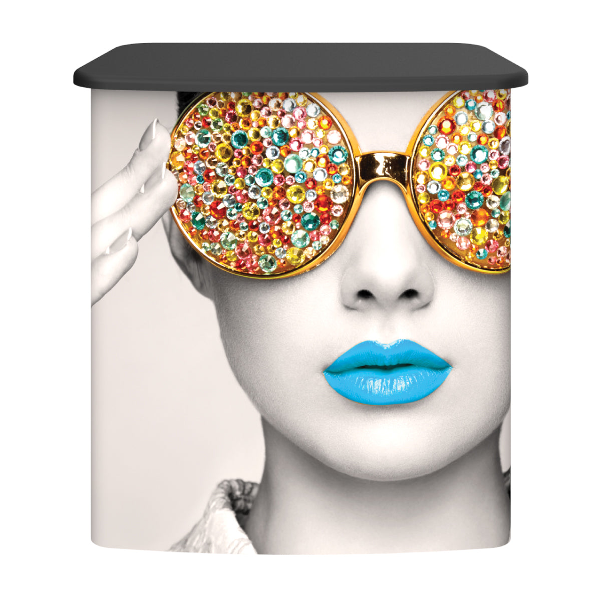 Trade show counter displaying large creative graphic of face with jewel-studded sunglasses and vibrant lips