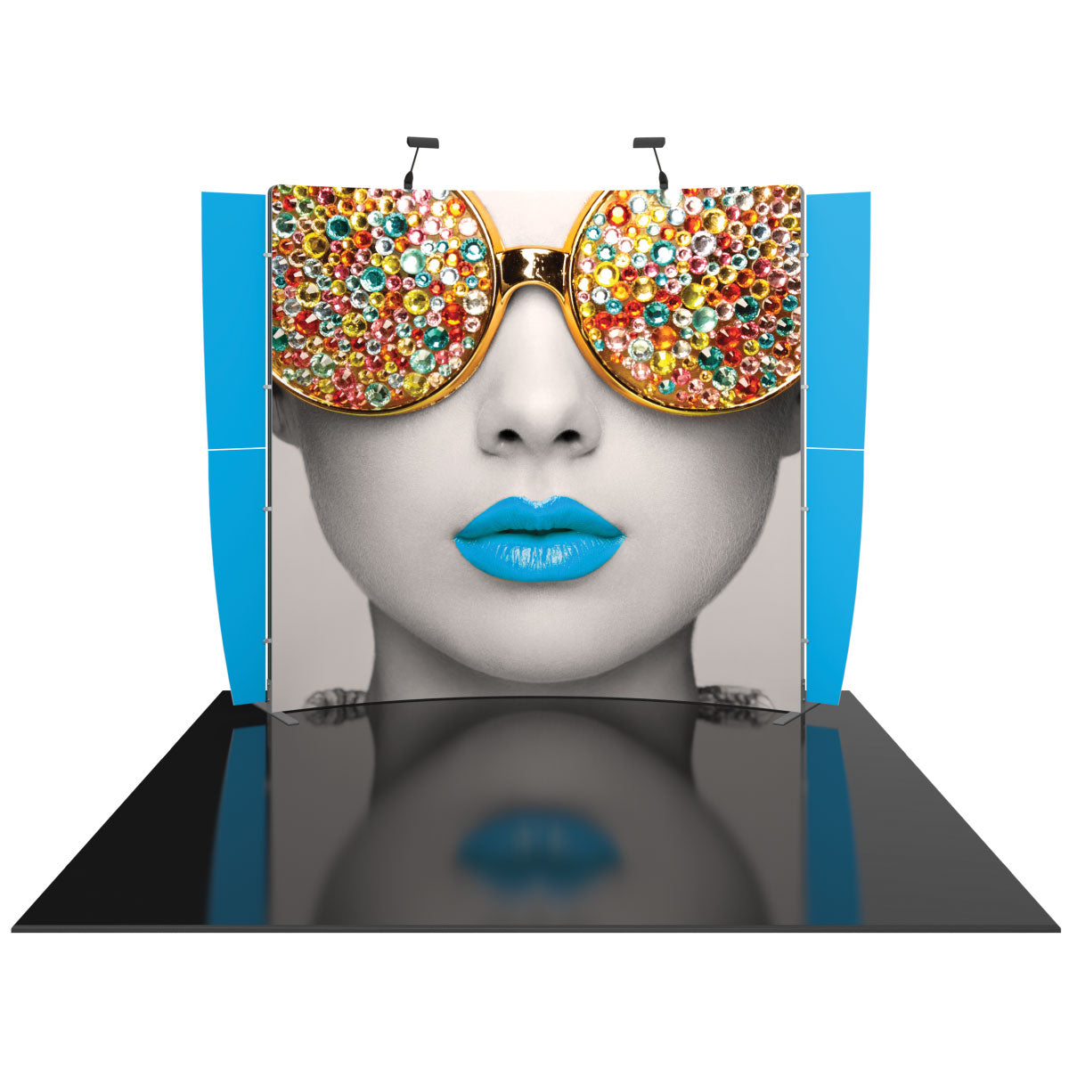 Trade show display featuring large portrait of woman with embellished sunglasses and vibrant lips