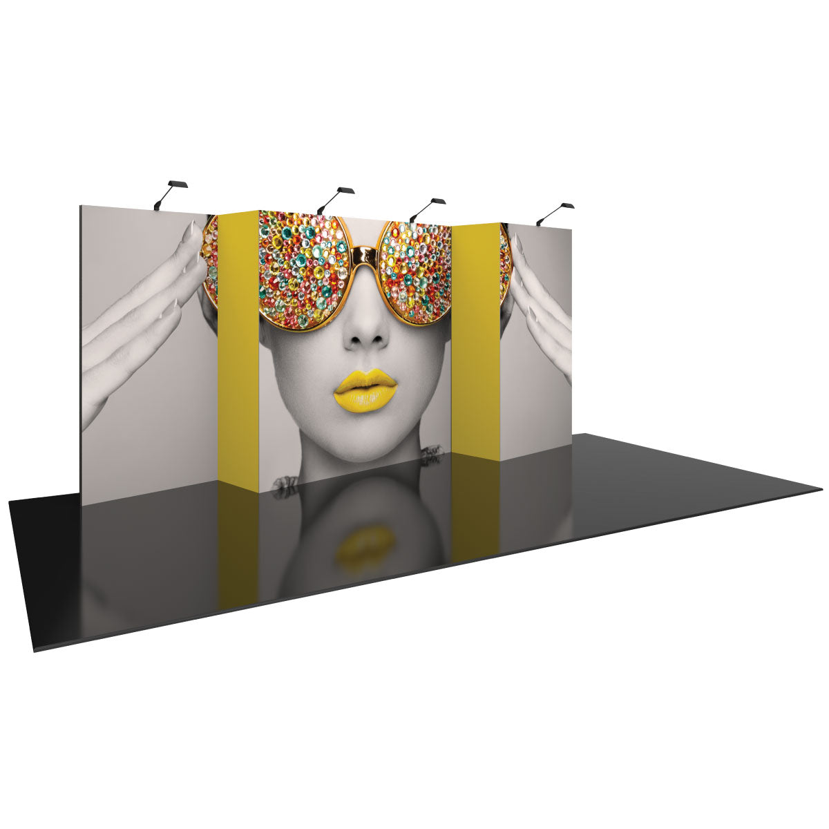Trifold exhibition display backdrop featuring a stylized portrait with decorative sunglasses and lit overhead for trade shows