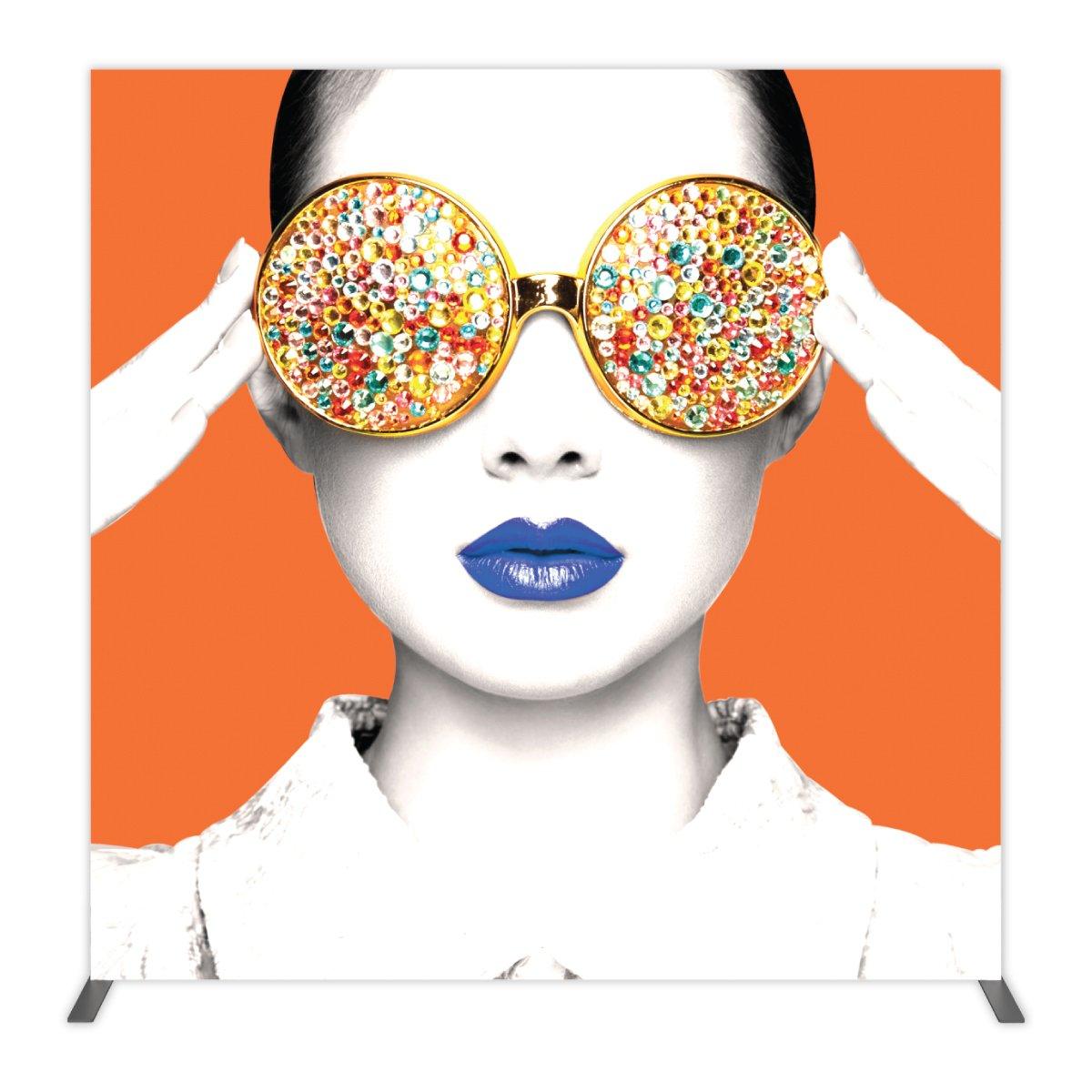Trade show backdrop featuring a stylized portrait of a woman with embellished eyewear and bold lipstick for exhibitions