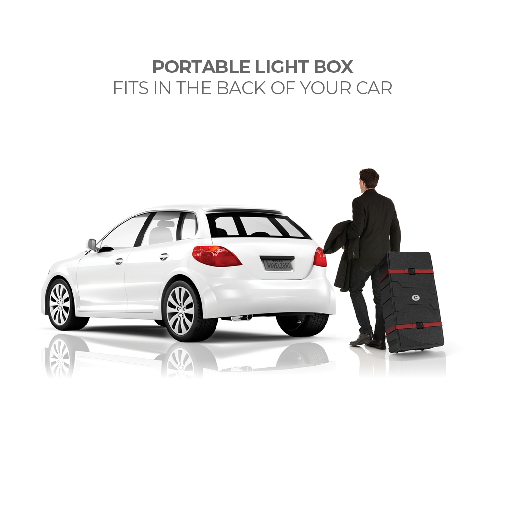 Man carrying portable light box with wheels next to a car, ideal for trade shows and events