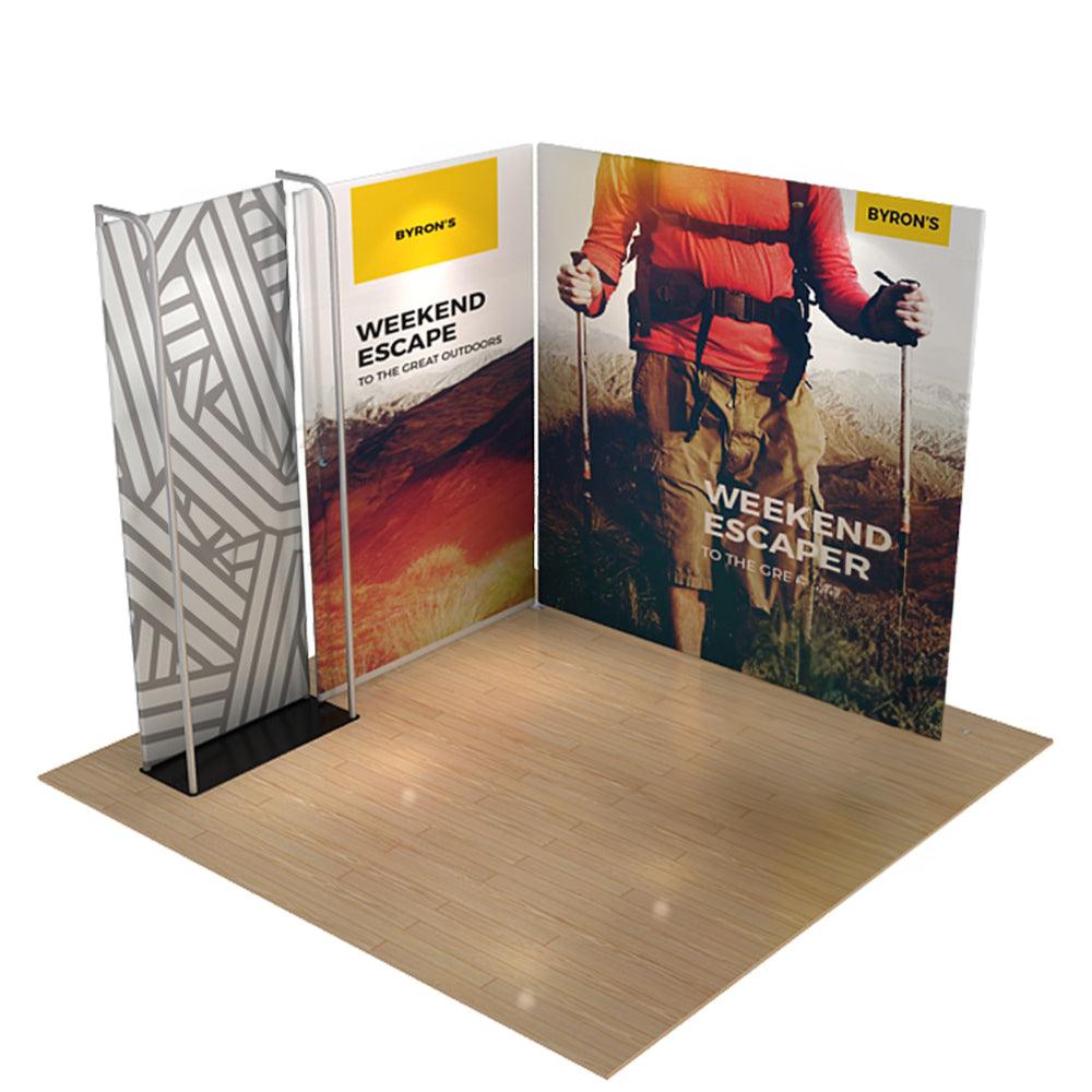 Trade show display featuring large fabric backdrops with outdoor adventure branding on wood floor