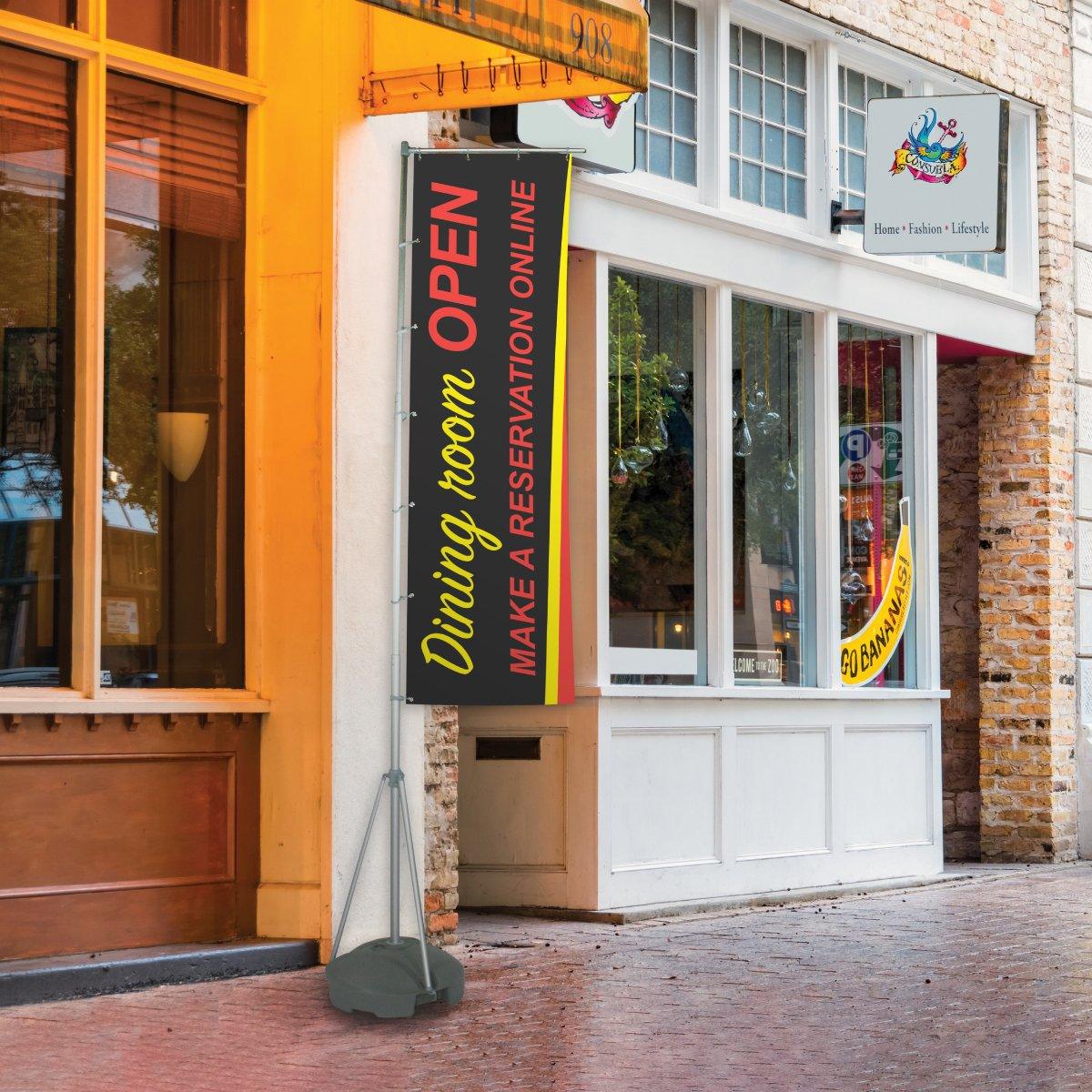 Vertical flag stand displaying promotional banner for dining room reservation in outdoor retail setting