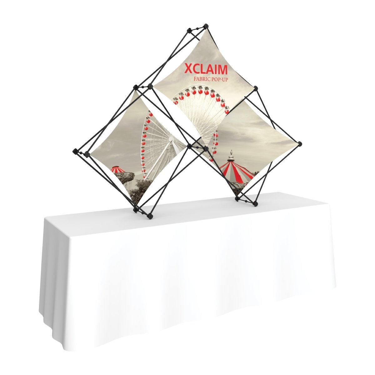Trade show fabric pop-up display with quad pyramid frame featuring carnival theme graphics on table