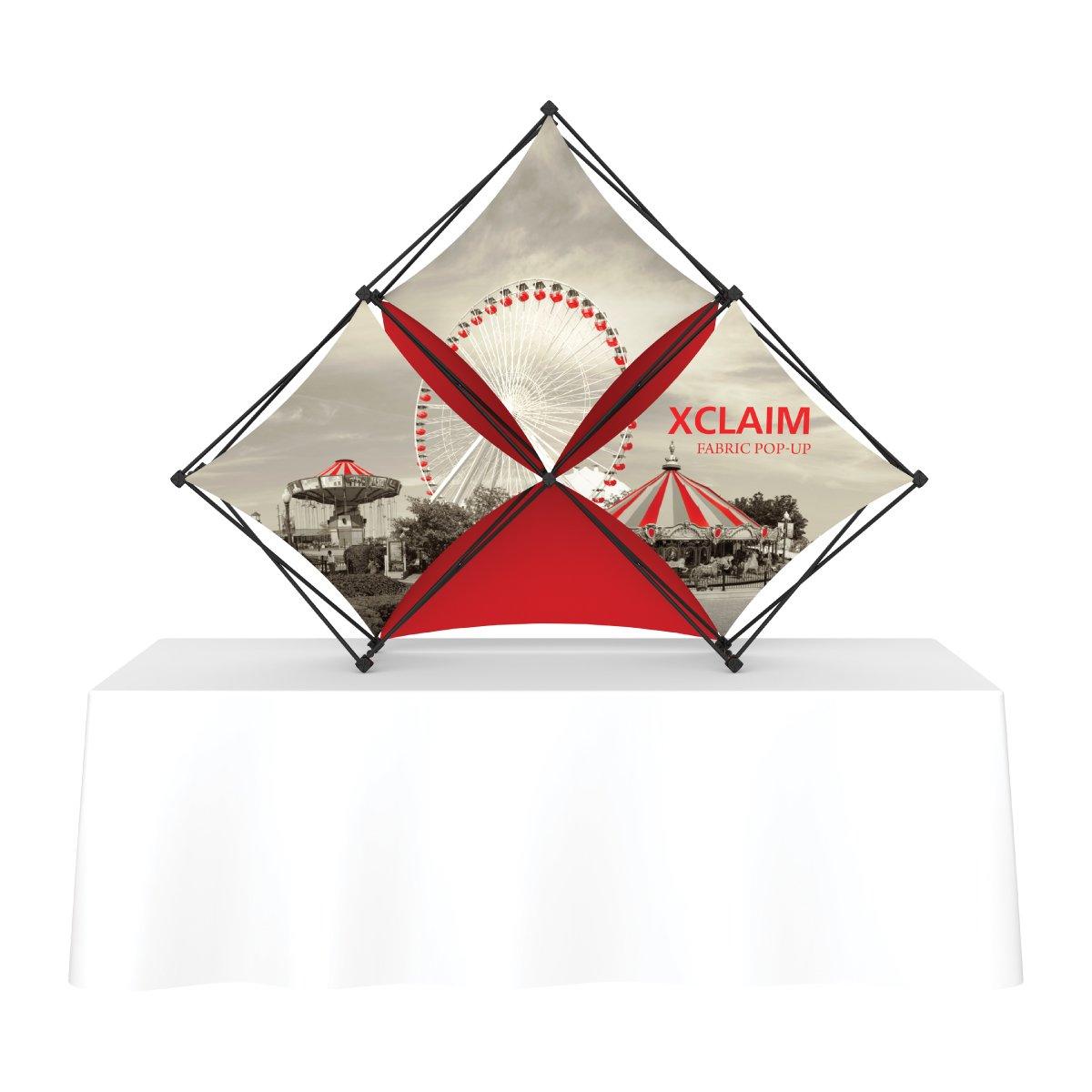 Xclaim fabric pop-up display with carnival print on table, ideal for trade shows and exhibitions