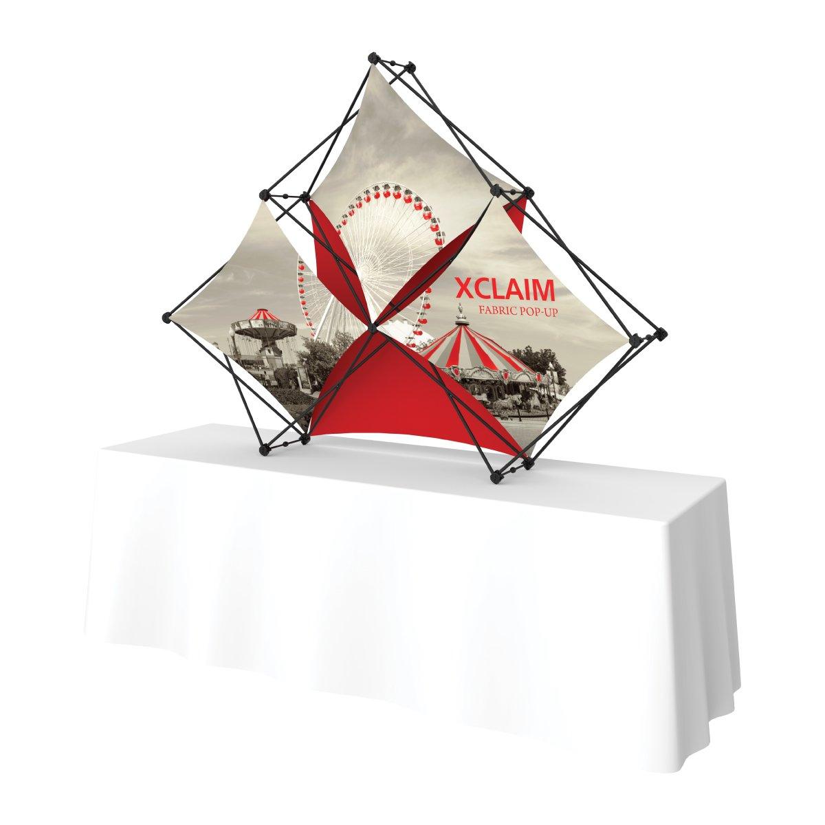 Xclaim fabric pop-up display on table for trade shows and exhibitions featuring graphic panels