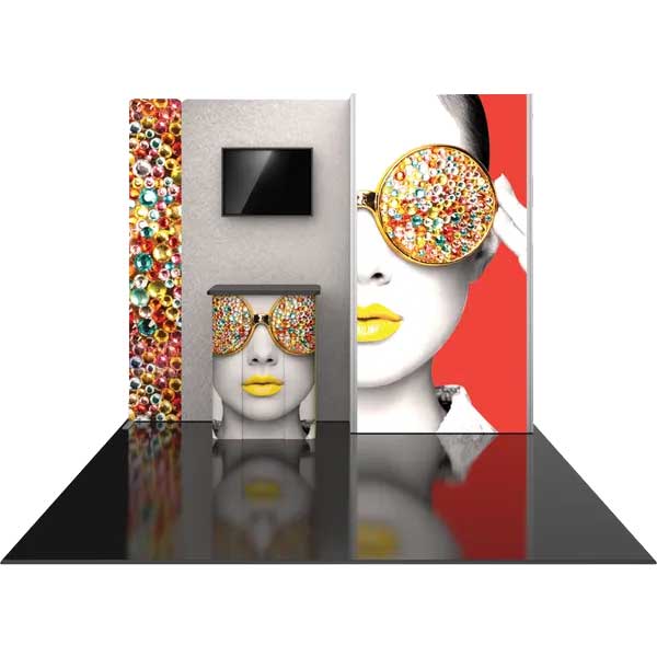 Trade show display booth with large graphic panels and counter featuring vibrant face artwork and monitor