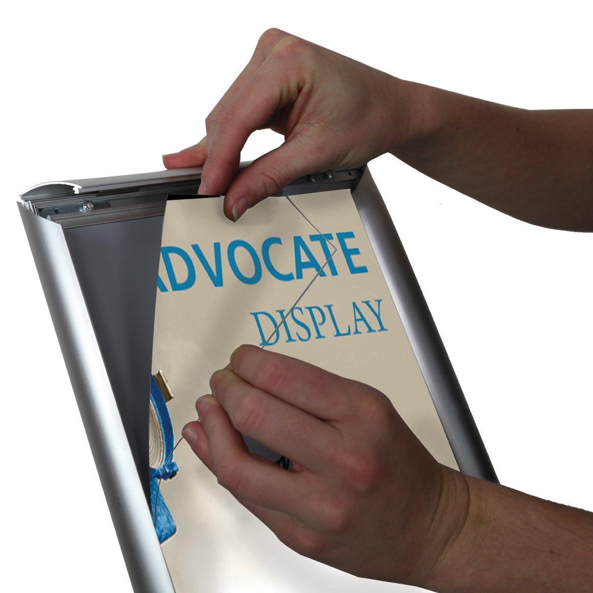 Hands inserting a promotional poster into an aluminum frame for trade show or exhibition display