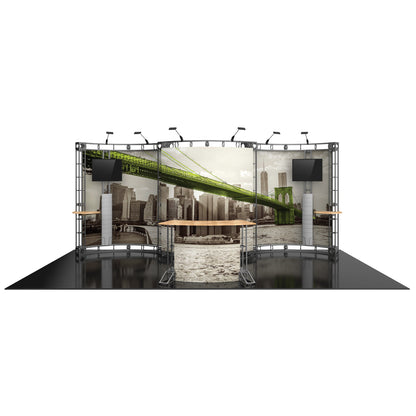 Modular exhibition display featuring curved truss structure with graphics, monitors, and counters for trade shows