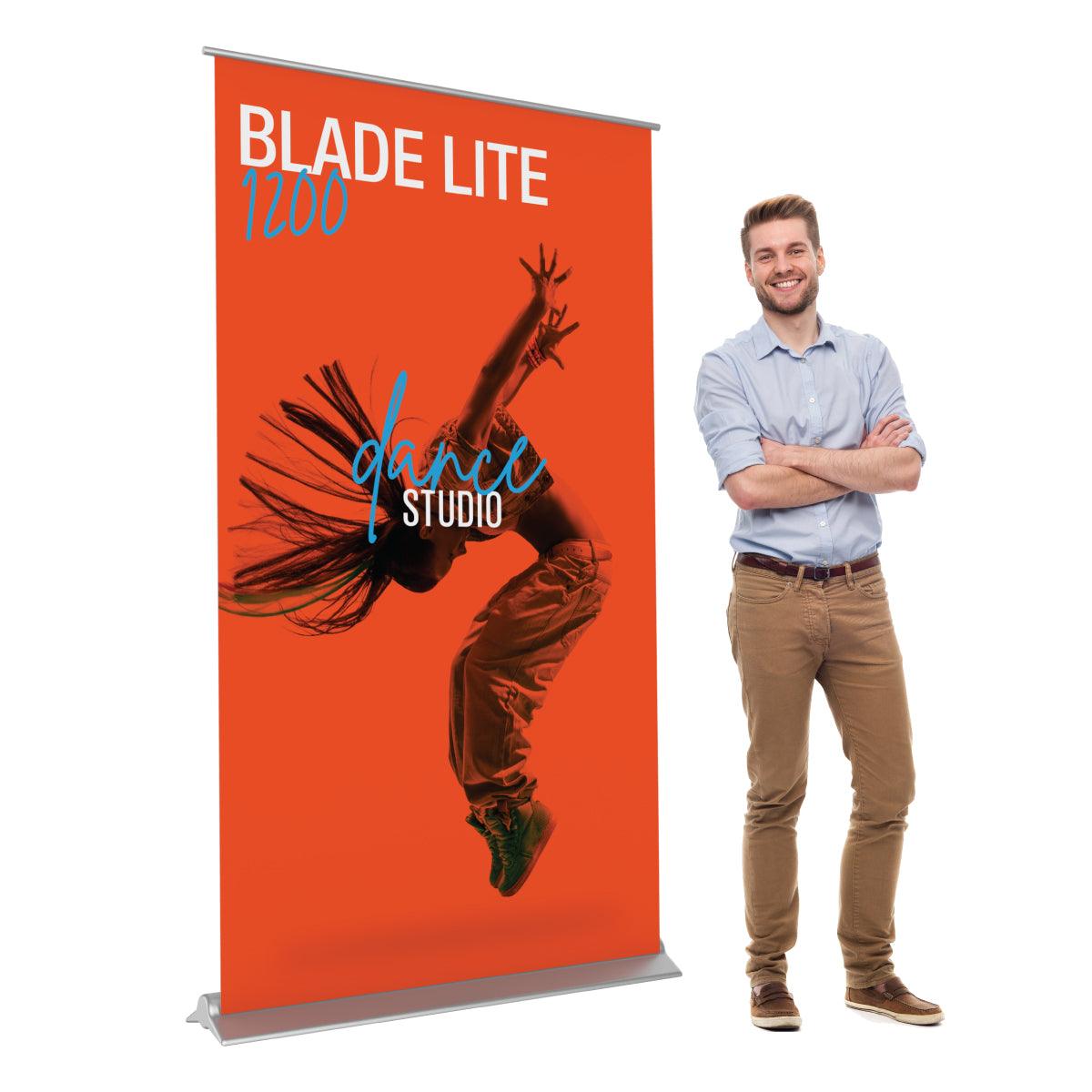 Blade Lite 1200 banner stand displaying dance studio advertisement beside a smiling man for trade shows and exhibitions