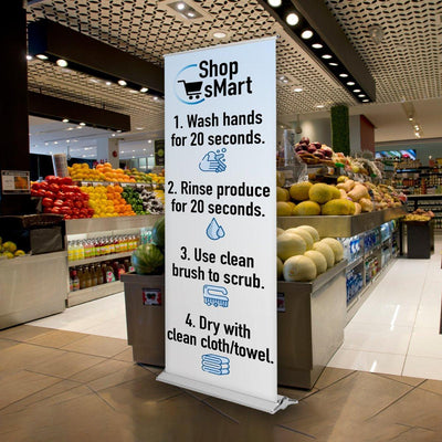 Retractable banner stand displaying hygiene instructions at a fresh produce market for trade shows and events