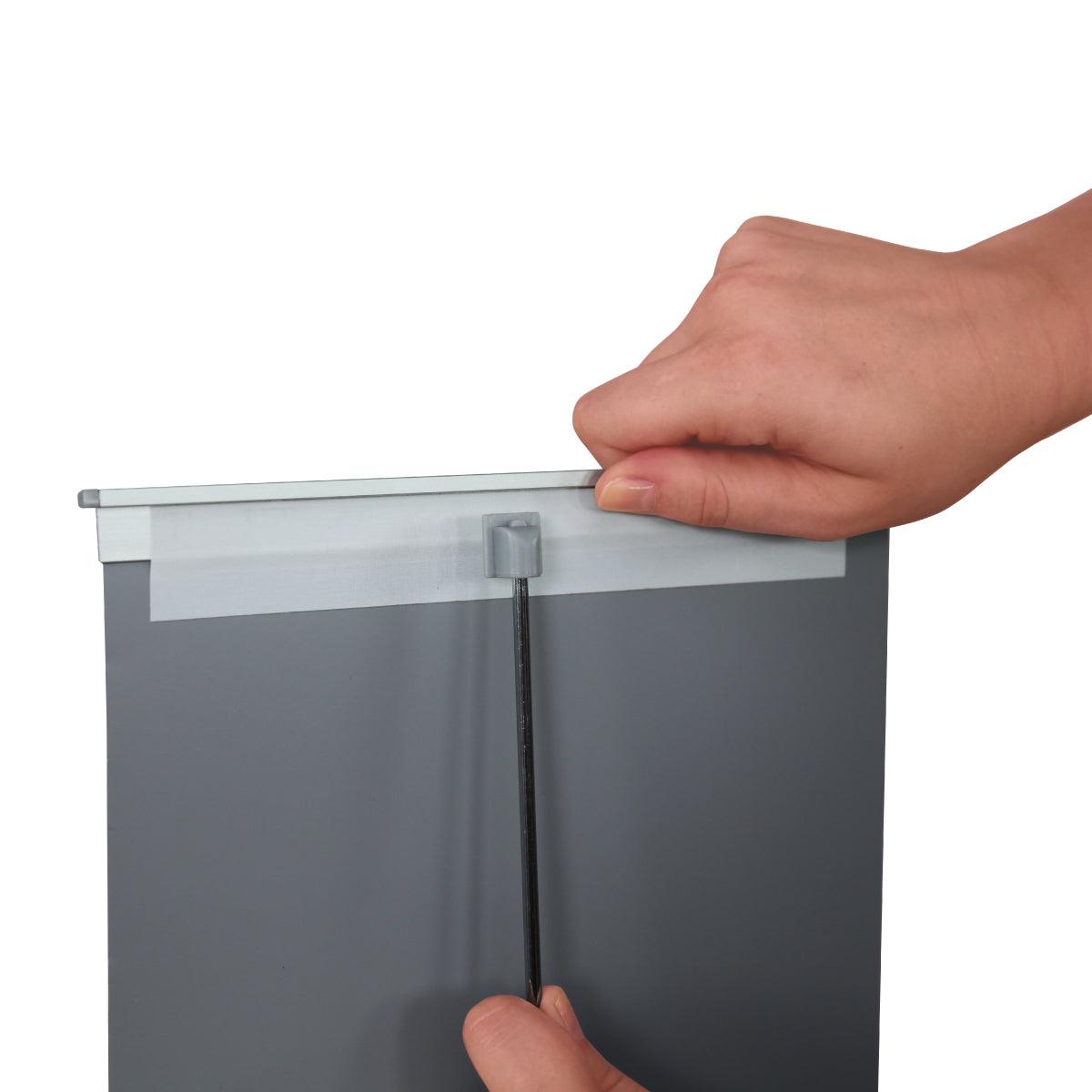 Hands assembling a tabletop banner stand with a pull-up graphic for trade show displays