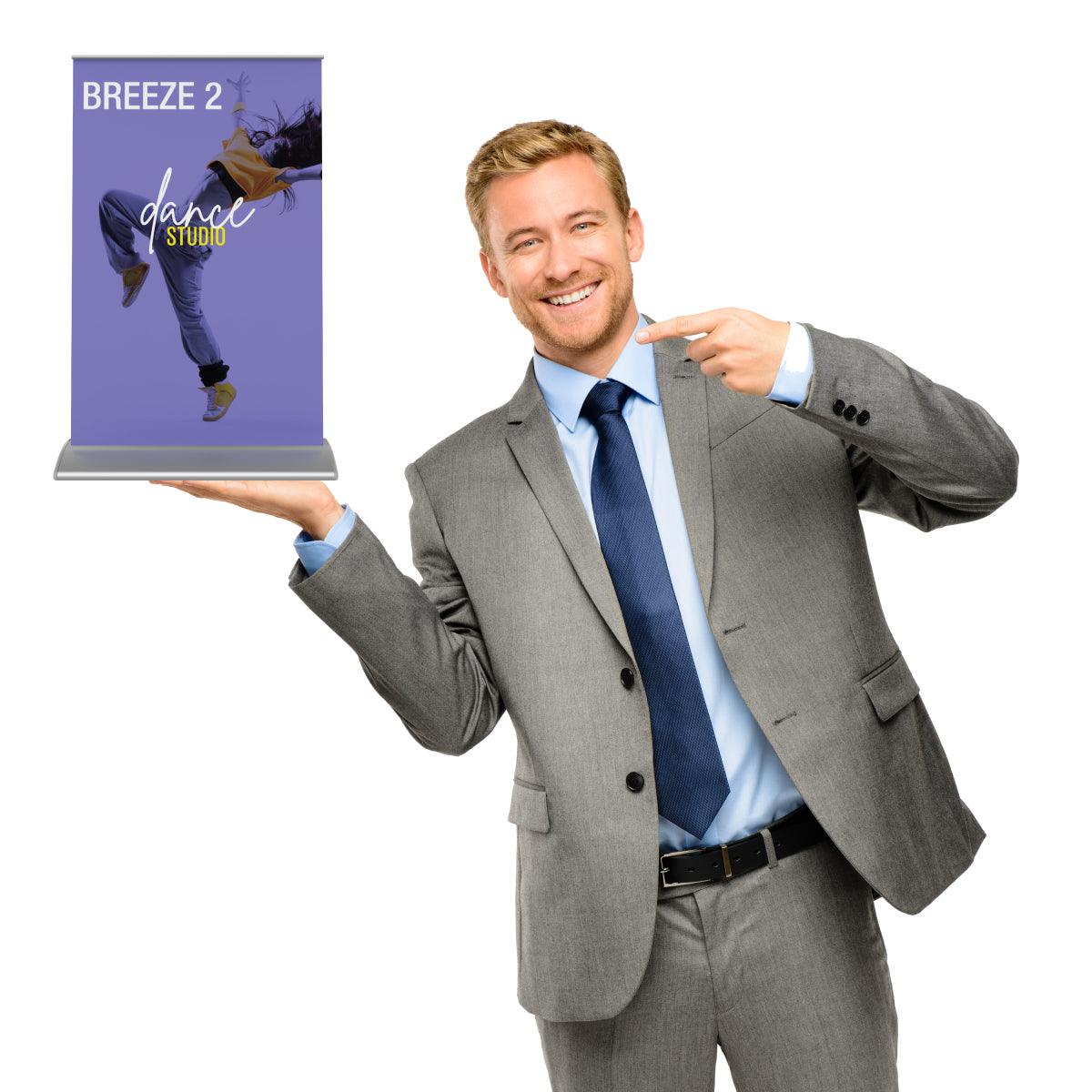 Businessman presenting Breeze 2 tabletop banner stand for trade shows, exhibitions, and events