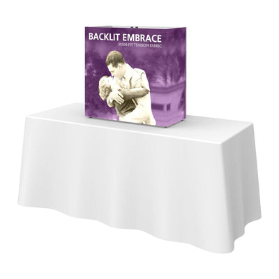 Backlit tabletop display with push-fit tension fabric on a draped trade show table for exhibitions