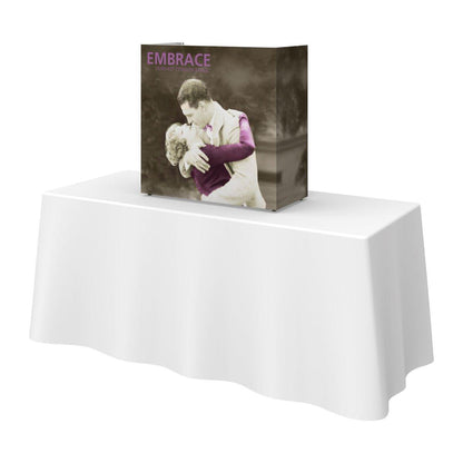 Compact 2.5ft tabletop display with fabric graphic showing embracing couple for trade shows and events