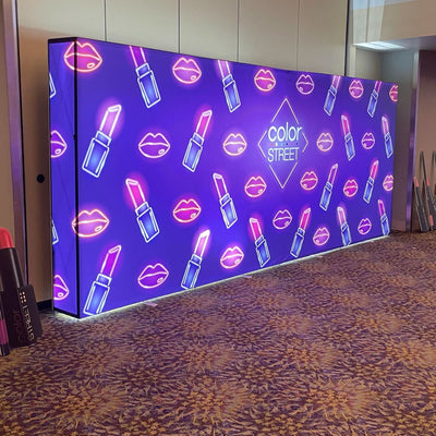 Large illuminated trade show display with lipstick and lip icons featuring Color Street branding