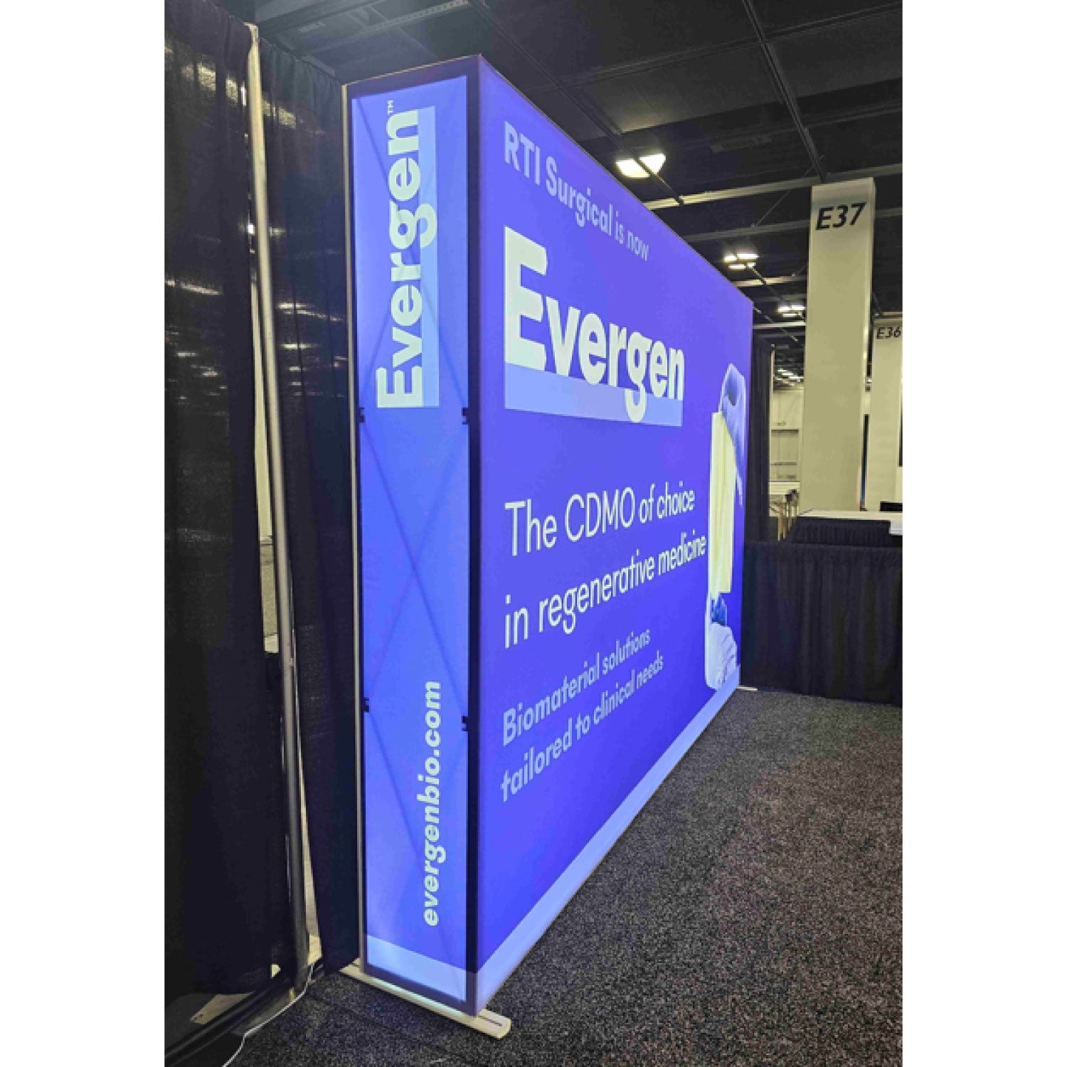 Large illuminated trade show display booth featuring Evergen branding and regenerative medicine messaging at an exhibition