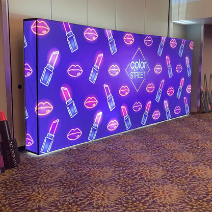 Large illuminated trade show backdrop featuring lipstick and lips graphics with Color Street branding