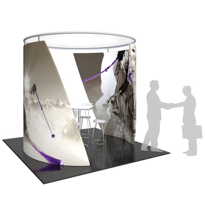 Curved trade show display with winter sports graphics featuring climbing and skiing scenes, including table and chairs inside booth
