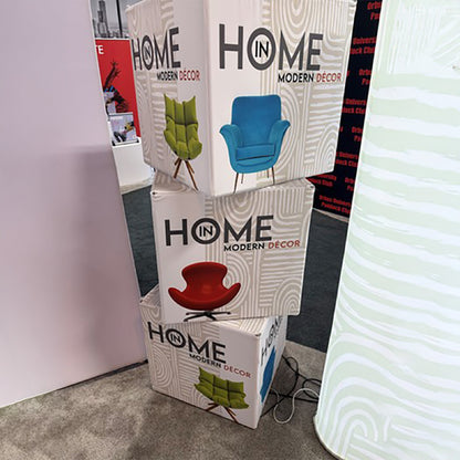 Stacked illuminated display cubes featuring modern décor chairs for trade shows and special events
