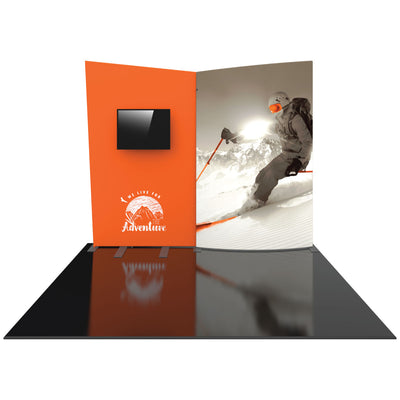 Trade show display with curved backdrop featuring skiing image and mountaineering logo, including mounted screen