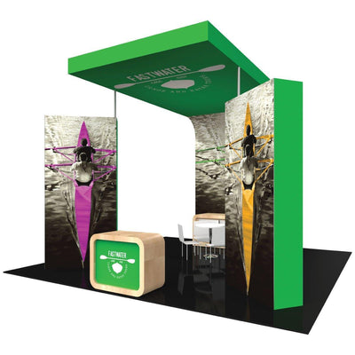 Trade show island booth with branded overhead signage, large kayak imagery, and seating area for exhibits