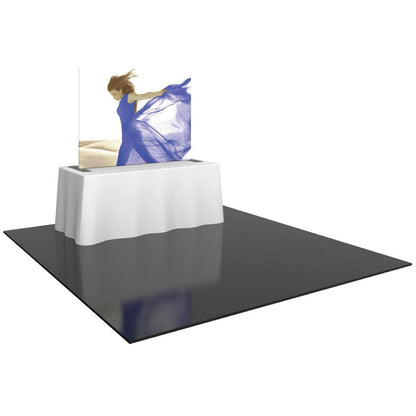 Tabletop trade show display with fabric graphic and white table cover on glossy floor