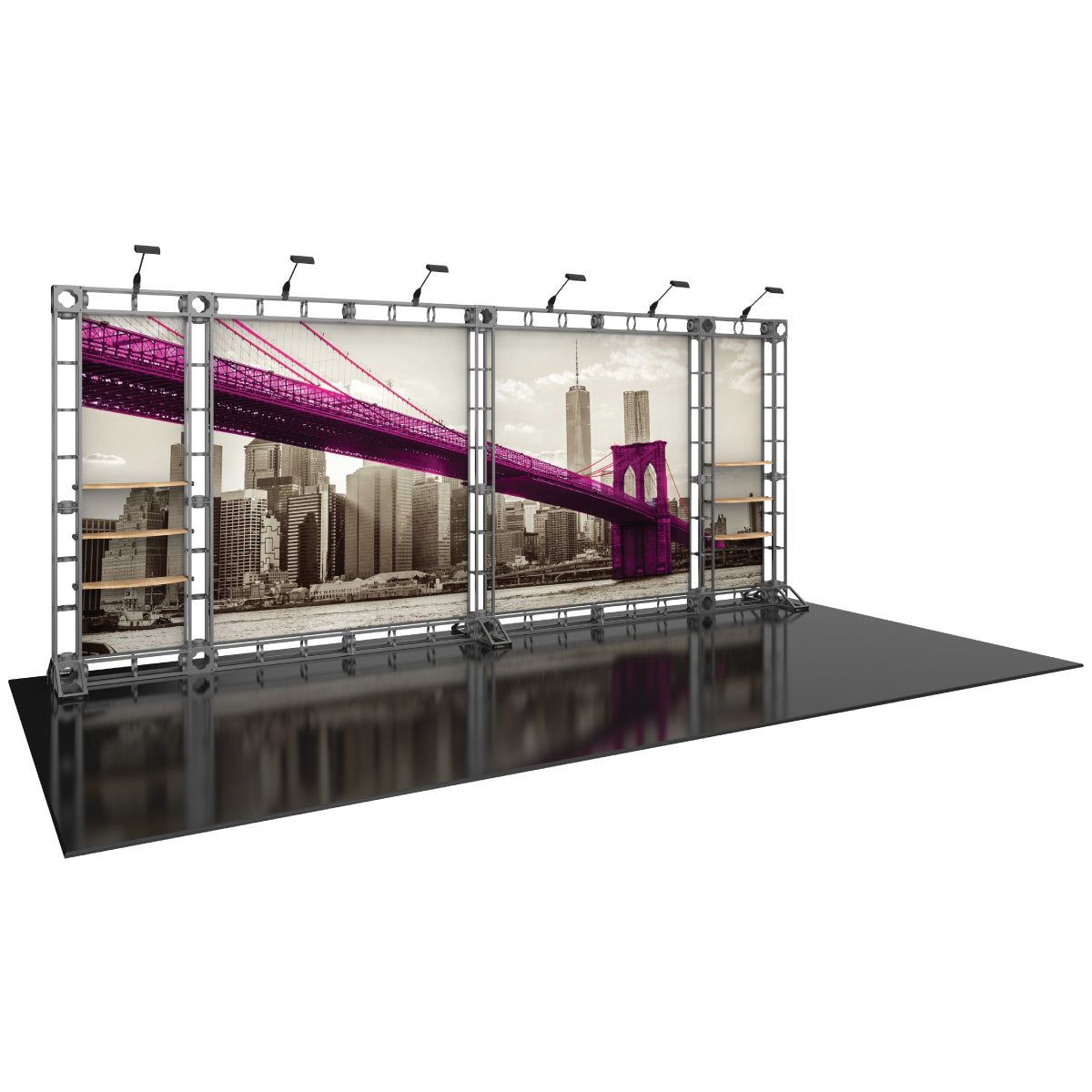 Three-panel trade show display with city skyline and bridge graphics, metal truss frame, shelving, and overhead lighting