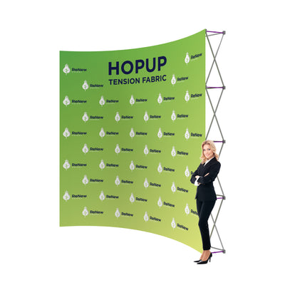 Trade show tension fabric display with branding and businesswoman standing beside it at exhibition