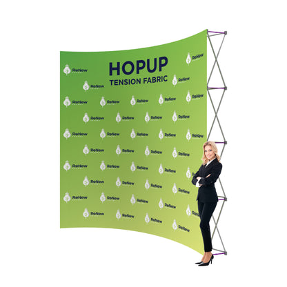 Trade show tension fabric display with branding and businesswoman standing beside it at exhibition