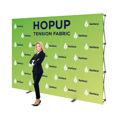 Trade show tension fabric backdrop with branded graphics and standing businesswoman at exhibition booth