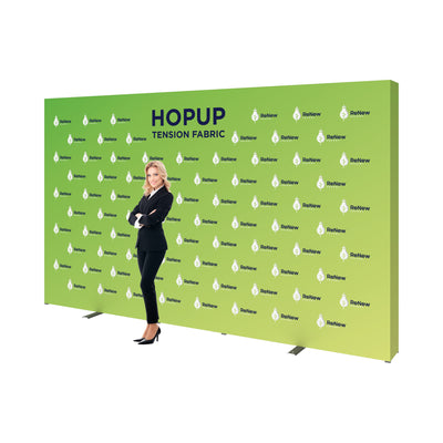 Large tension fabric trade show backdrop with ReNew Energy branding and a professional woman standing beside it