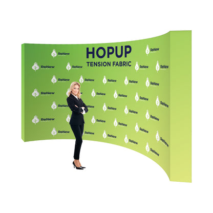 Curved tension fabric trade show backdrop with branded graphics and businesswoman standing in front
