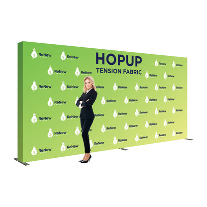 Large tension fabric trade show display with branded backdrop and businesswoman posing