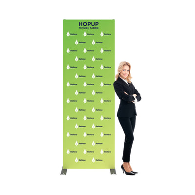 Tension fabric trade show display with renewable energy branding, businesswoman standing beside it