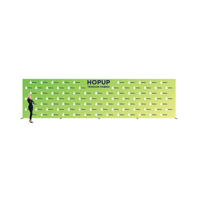 Large tension fabric backdrop display for trade shows with repeated logo branding and a standing woman