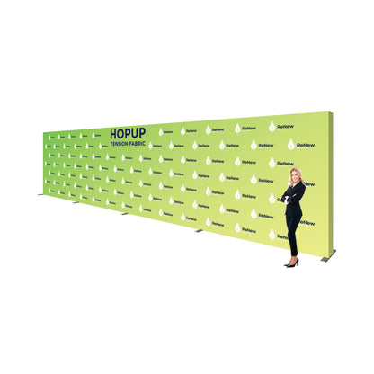 Large tension fabric backdrop for trade shows and exhibitions with branded graphics and a professional woman standing beside it