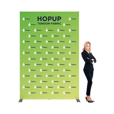 Large tension fabric backdrop with logos for trade shows and exhibitions next to businesswoman