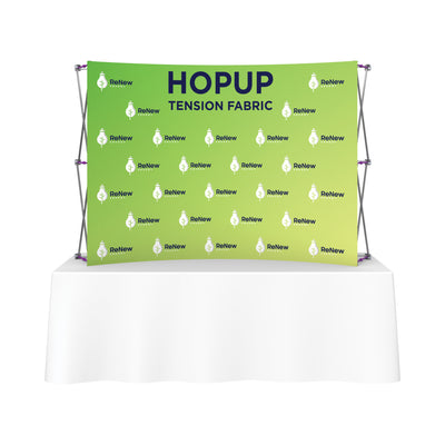 Trade show tension fabric backdrop with branded logo display on frame behind table
