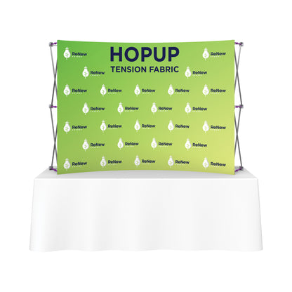 Trade show tension fabric backdrop with branded logo display on frame behind table