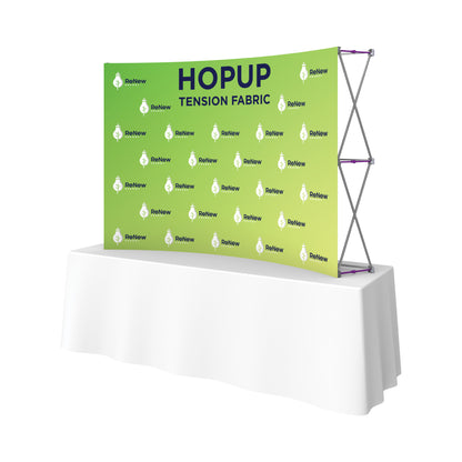 Curved tension fabric display on table for trade shows and exhibitions featuring branded graphic