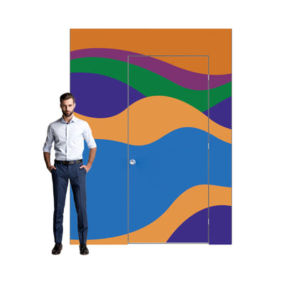 Modular trade show wall with door featuring vibrant wavy graphic panels next to a standing man