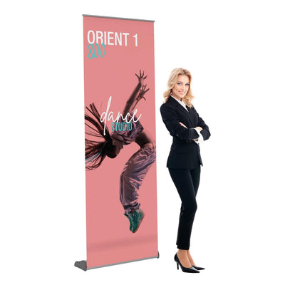 Professional woman standing next to a portable banner stand with dance studio advertisement for trade shows