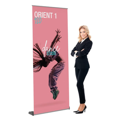 Retractable banner stand with dance studio graphic beside a professional woman in business attire for trade shows